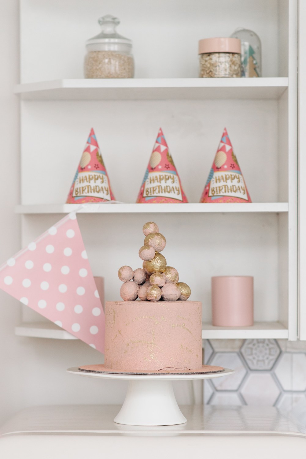 Decorated pink celebration cake with an ornate topping