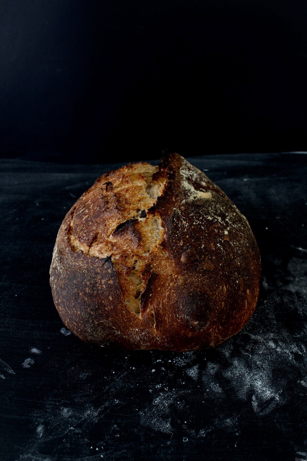 Rustic round sourdough loaf with a scored crust