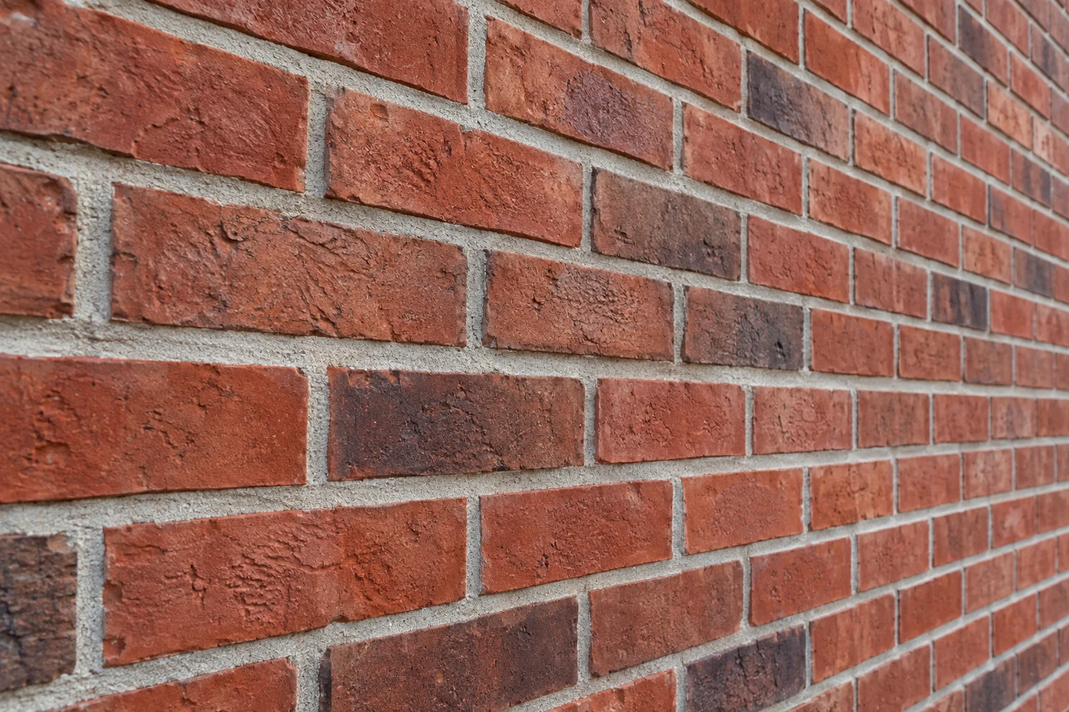 Close-up concept of red clay brick in a running bond with gray mortar